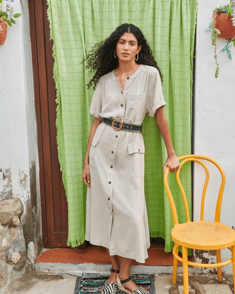 woman in natural linen maxi dress leaning on chair
